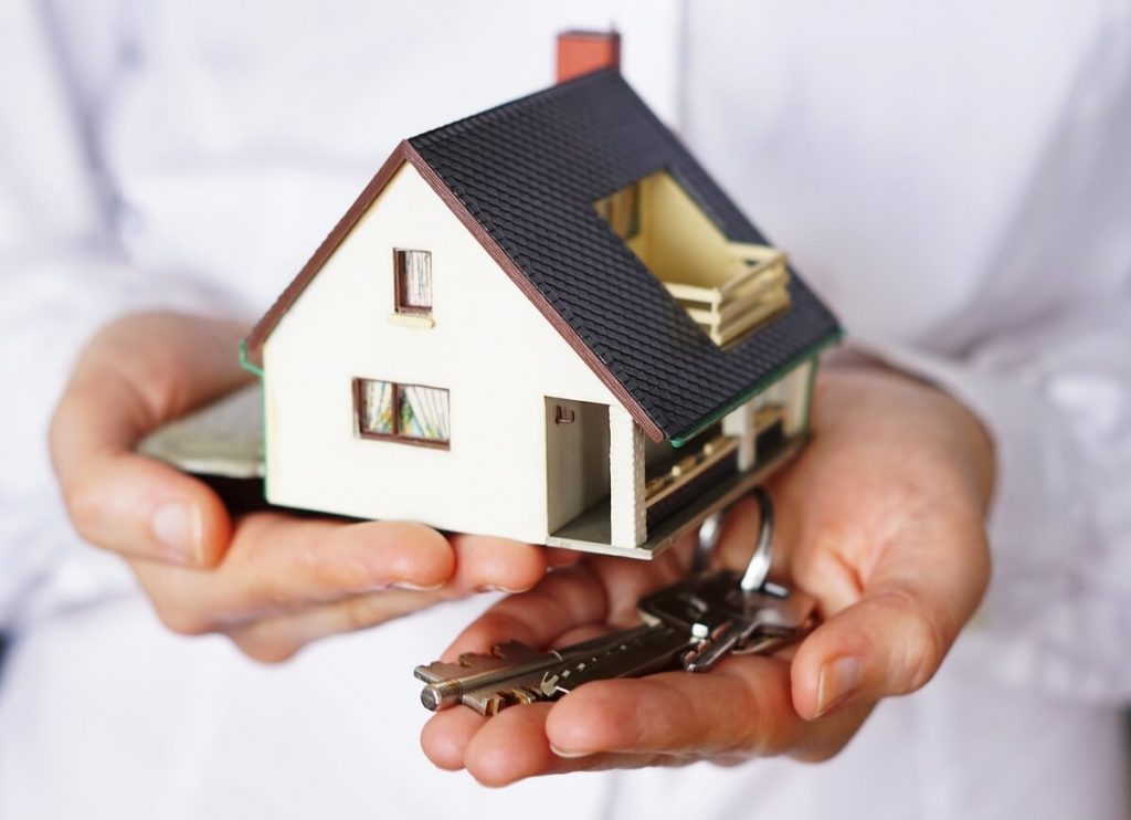mãos a segurar casa com transferência de crédito habitação para renegociação de créditos
